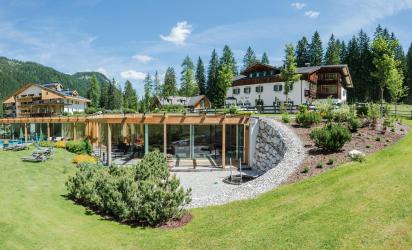Hotel Dolomitenhof mit Badehaus und Garten im Sommer