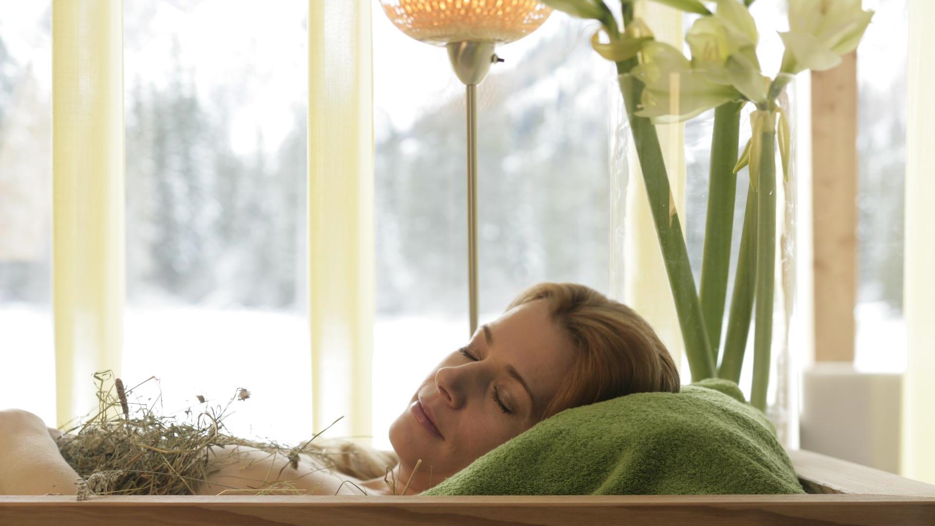 Una donna nel bagno di fieno